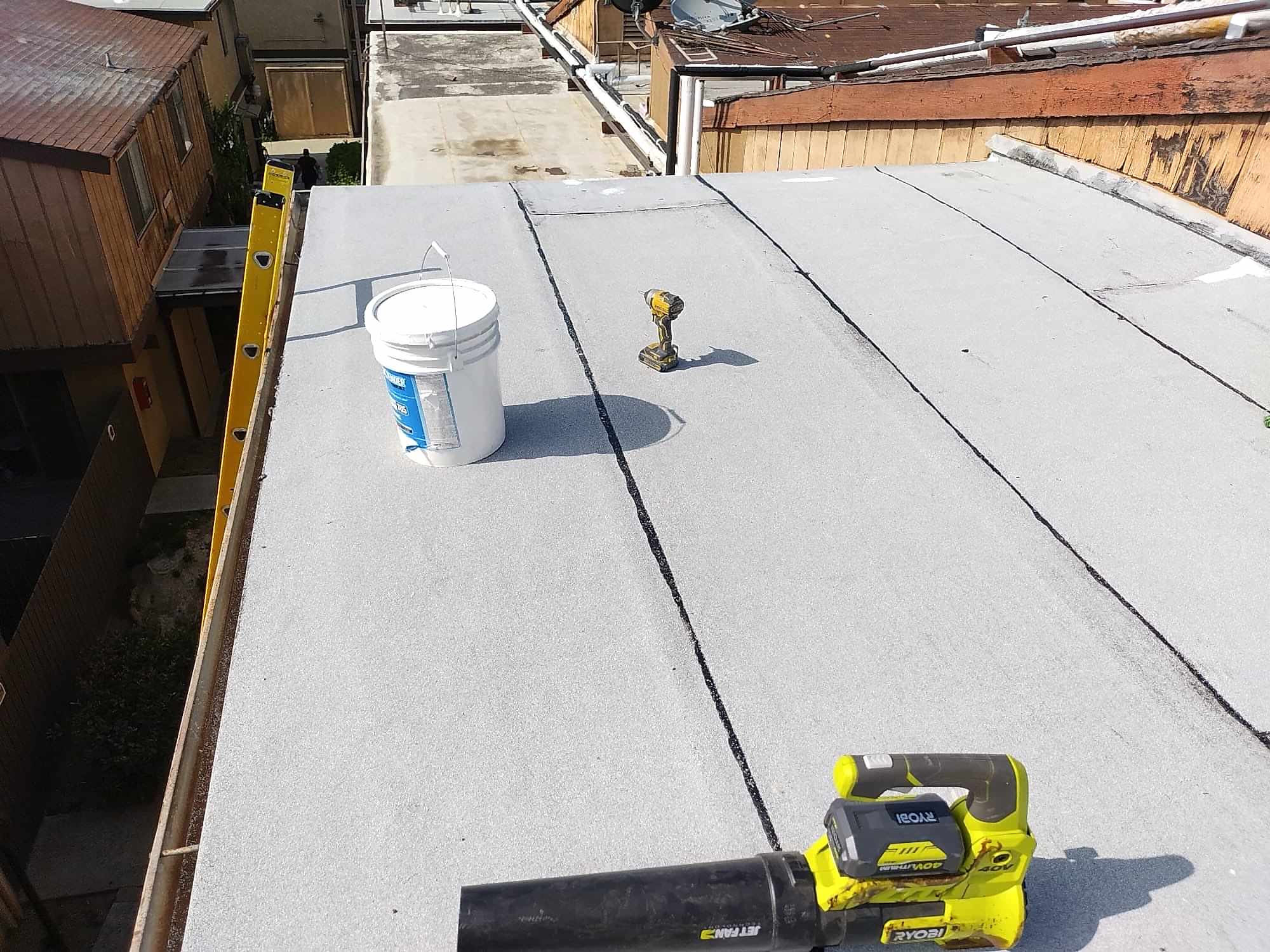 1-Jun 05 2024 09_22am-QLAR Commercial flat roof with a fresh coating and repair tools