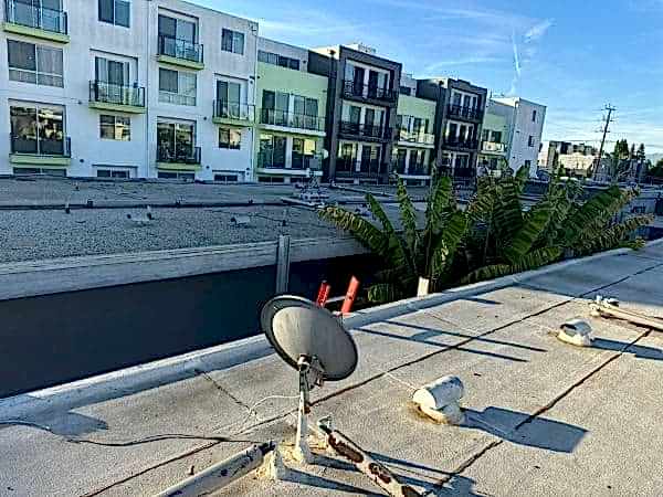 Flat roof surface with sealed penetrations and drainage
