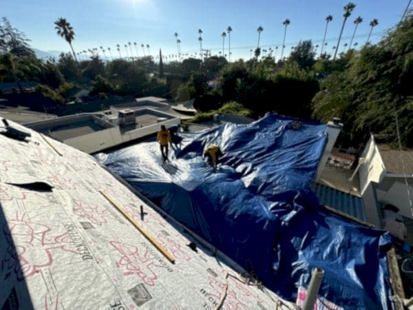 Roof covered with a protective tarp while a leak is repaired