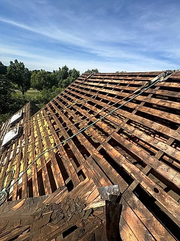 Exposed roof rafters and decking during a structural roof repair