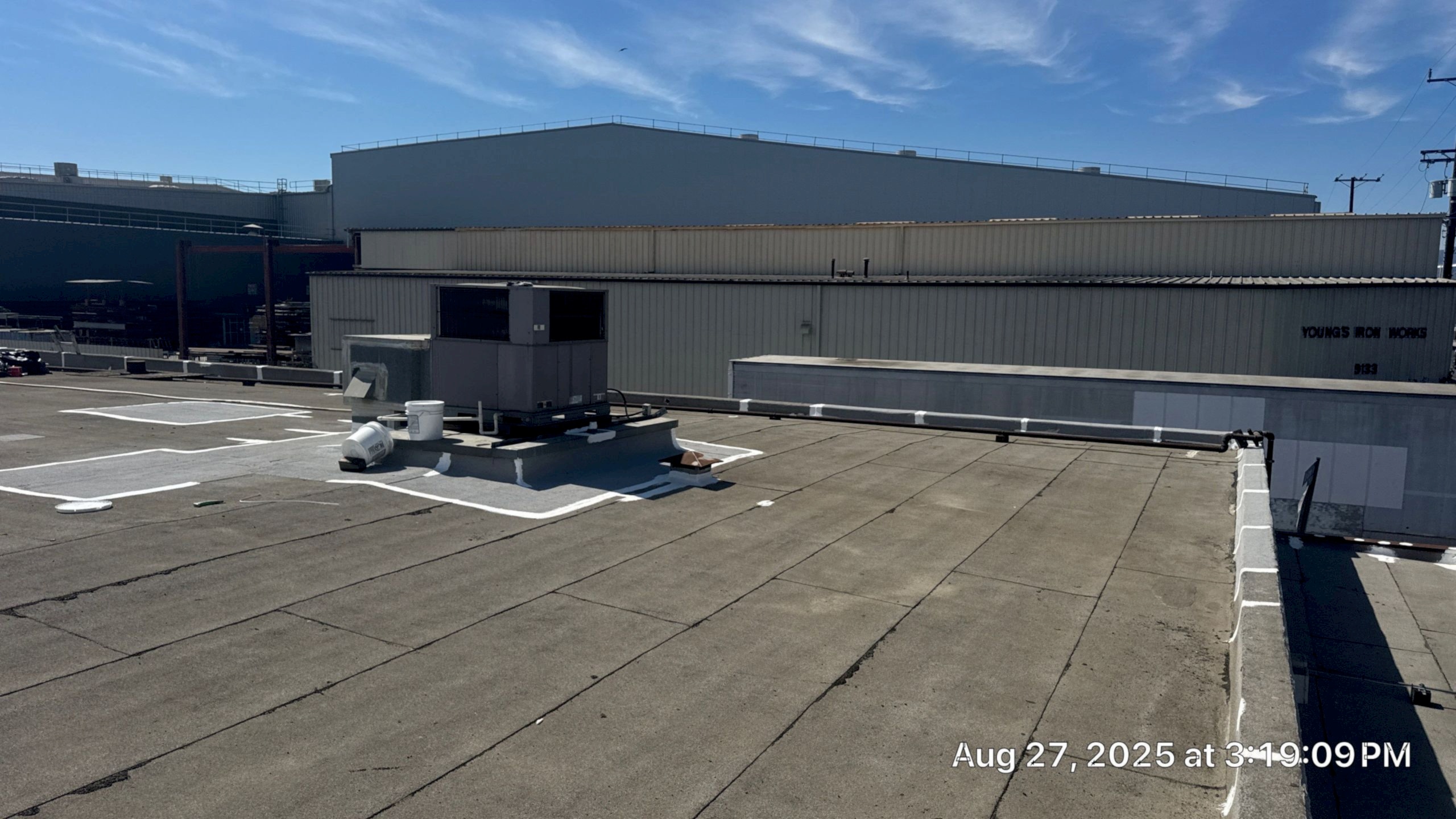 Industrial rooftop with HVAC unit and clear sky.