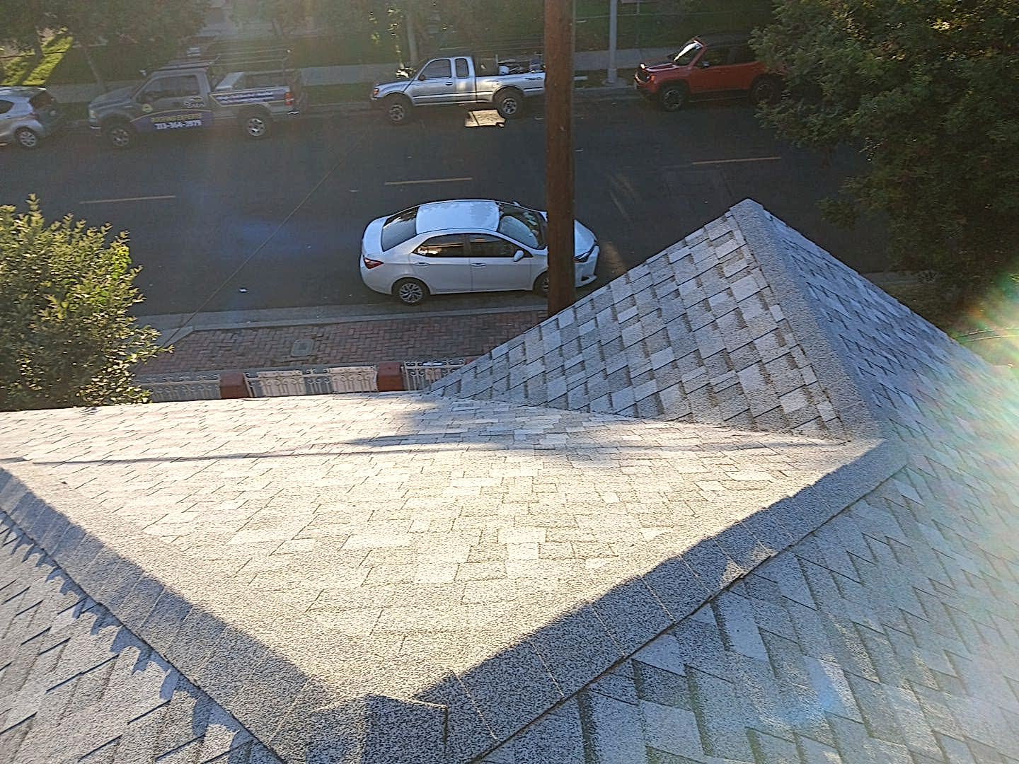 View of street from rooftop with shingles