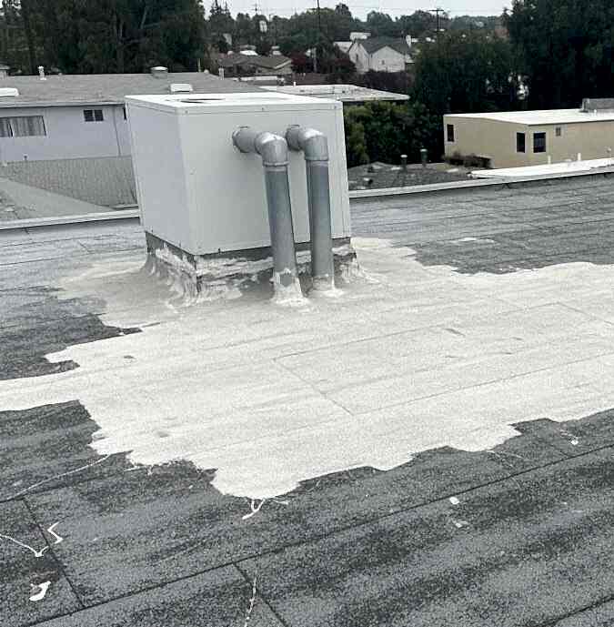 emergency-roof-repair-flat-roof-water-patch-los-angeles Flat roof with emergency sealant worked around a rooftop unit and its pipe penetrations to stop water entry