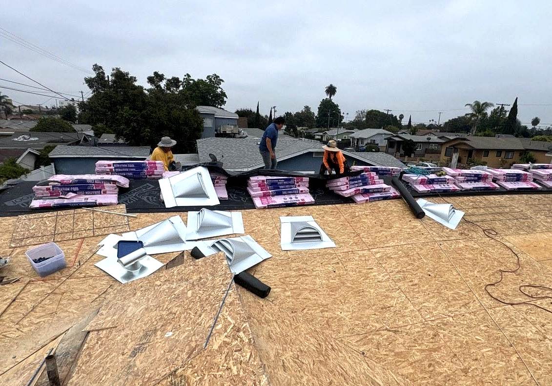 emergency-roof-repair-roof-stripped-to-decking-los-angeles Roof stripped back to bare decking with replacement roofing material and vents staged along the ridge